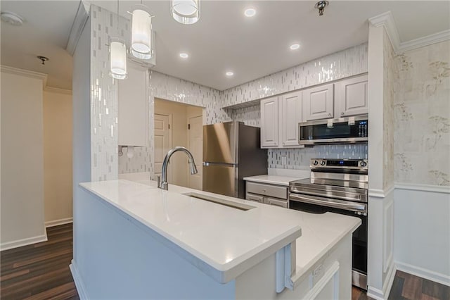 kitchen with appliances with stainless steel finishes, white cabinetry, dark wood-type flooring, and crown molding