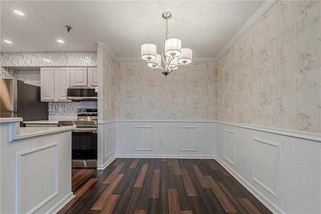 kitchen featuring stainless steel appliances, white cabinetry, dark wood-type flooring, and crown molding