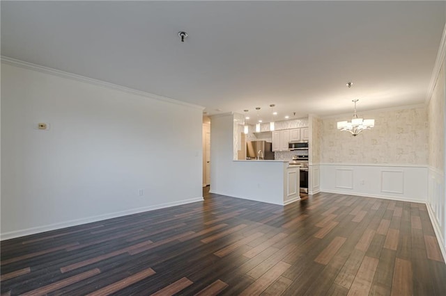 unfurnished living room featuring dark hardwood / wood-style floors, an inviting chandelier, and crown molding