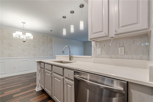 kitchen featuring stainless steel dishwasher, crown molding, sink, dark hardwood / wood-style floors, and hanging light fixtures