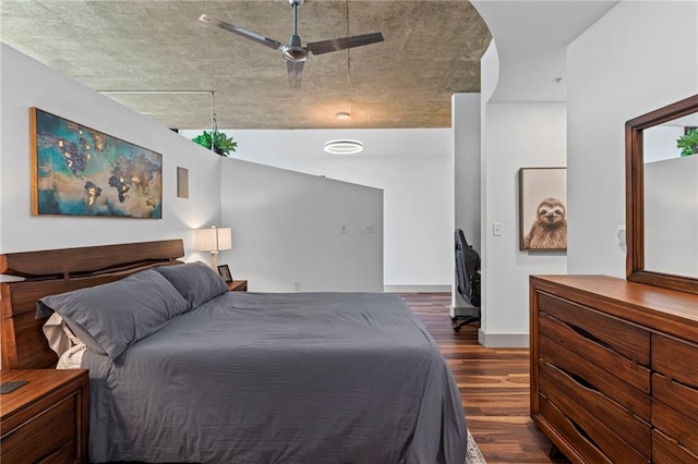 bedroom with dark wood-type flooring, a ceiling fan, and baseboards