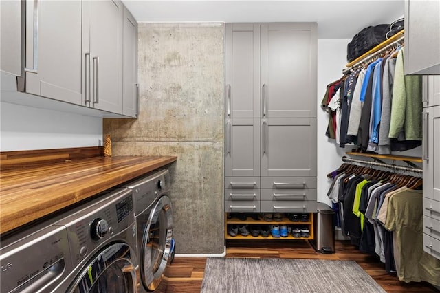 washroom featuring cabinet space, washing machine and dryer, and dark wood finished floors