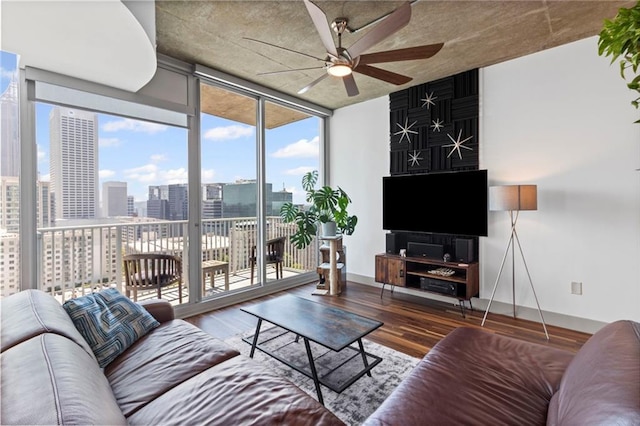 living area with ceiling fan, wood finished floors, expansive windows, and baseboards