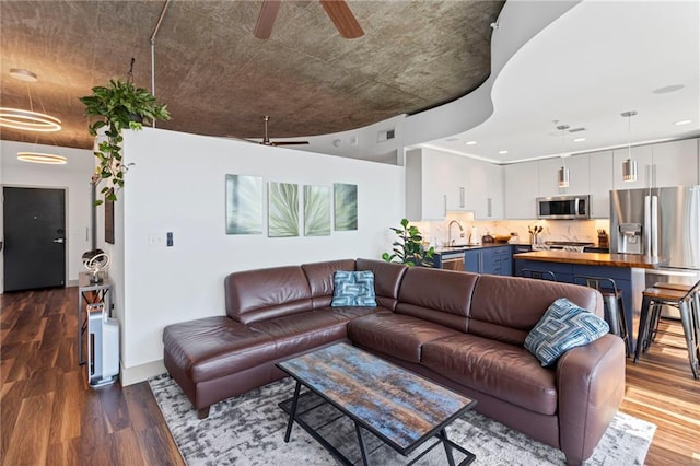 living area with a ceiling fan, dark wood-style floors, and recessed lighting