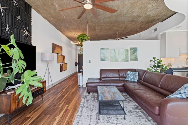 living room featuring ceiling fan, wood finished floors, and baseboards