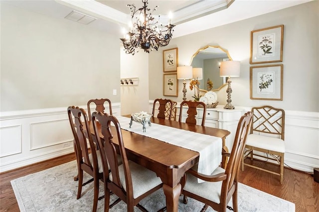 4401 Madison Woods Dr NW, Marietta, GA 30064 - dining room featuring wood finished floors, a chandelier, a wainscoted wall, a decorative wall, and a raised ceiling