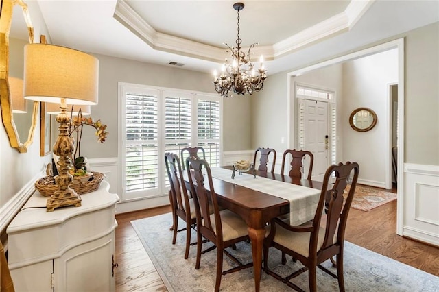 4401 Madison Woods Dr NW, Marietta, GA 30064 - dining area featuring a chandelier, a tray ceiling, ornamental molding, wood finished floors, and wainscoting