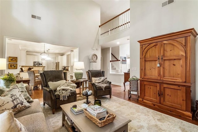4401 Madison Woods Dr NW, Marietta, GA 30064 - living room featuring a towering ceiling, stairs, and light wood-type flooring