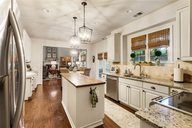 4401 Madison Woods Dr NW, Marietta, GA 30064 - kitchen featuring appliances with stainless steel finishes, backsplash, butcher block countertops, a center island, and recessed lighting