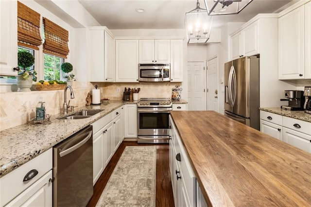 4401 Madison Woods Dr NW, Marietta, GA 30064 - kitchen with stainless steel appliances, wooden counters, dark wood-style floors, white cabinets, and a chandelier