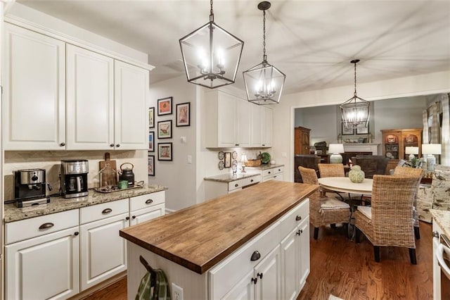 4401 Madison Woods Dr NW, Marietta, GA 30064 - kitchen featuring a chandelier, butcher block counters, a center island, dark wood-style flooring, and white cabinets