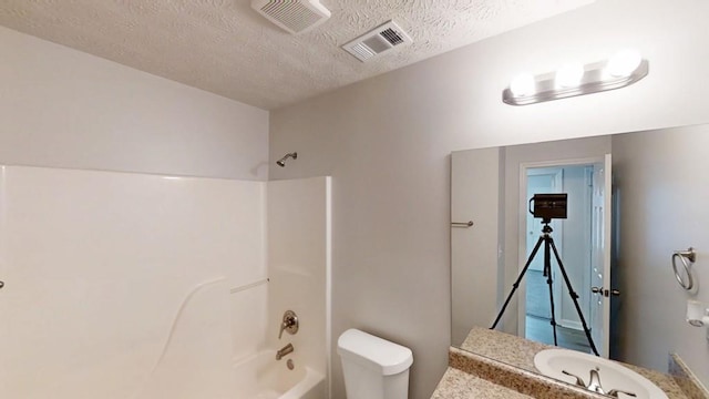 bathroom featuring toilet, a textured ceiling, tub / shower combination, and visible vents