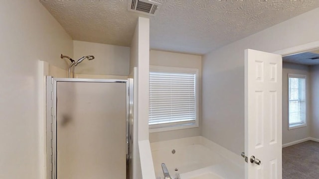 bathroom with a whirlpool tub, a stall shower, visible vents, and a textured ceiling