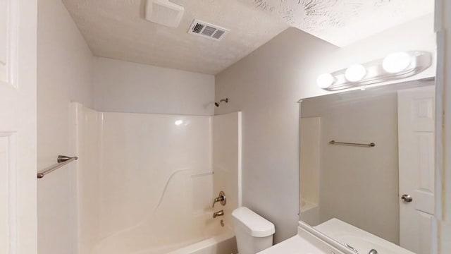 full bathroom featuring visible vents, shower / bathing tub combination, toilet, vanity, and a textured ceiling