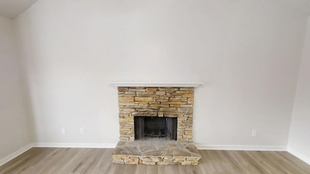 unfurnished living room with a fireplace, wood finished floors, and baseboards