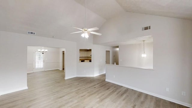 unfurnished living room with high vaulted ceiling, visible vents, wood finished floors, and ceiling fan with notable chandelier