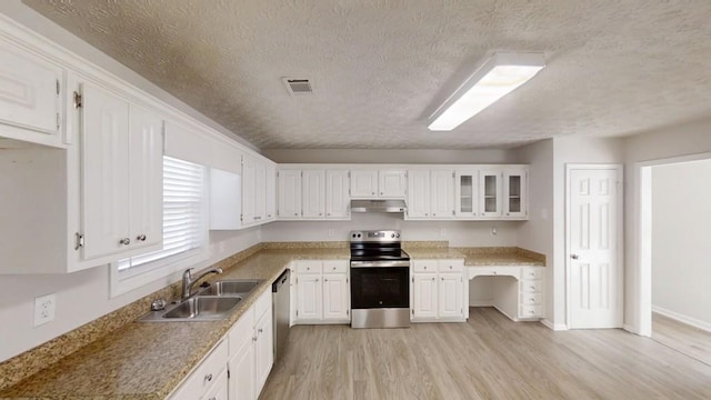 kitchen featuring light wood finished floors, stainless steel appliances, under cabinet range hood, white cabinetry, and a sink