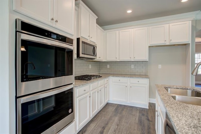 kitchen with dishwasher, an island with sink, light stone countertops, a wealth of natural light, and sink