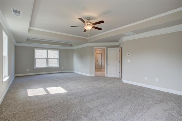 unfurnished room featuring a tray ceiling, crown molding, light colored carpet, and ceiling fan