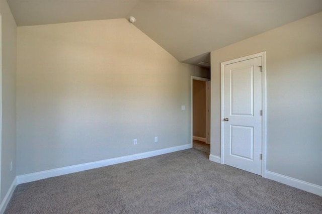 empty room featuring light colored carpet and lofted ceiling