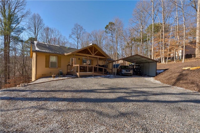 view of front facade with crawl space, a carport, driveway, and a shingled roof