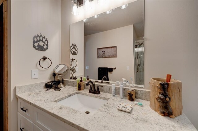 bathroom with vanity and a shower with shower door