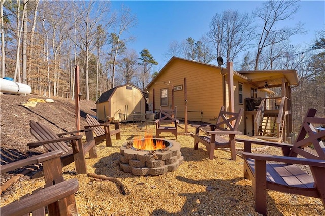 view of yard with a storage shed and an outdoor fire pit