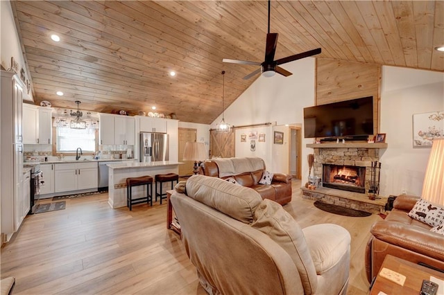 living room featuring high vaulted ceiling, a stone fireplace, light wood-style flooring, and wooden ceiling