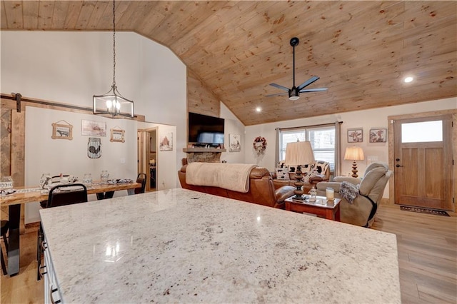 kitchen featuring wood ceiling, ceiling fan, light stone counters, decorative light fixtures, and light wood-type flooring