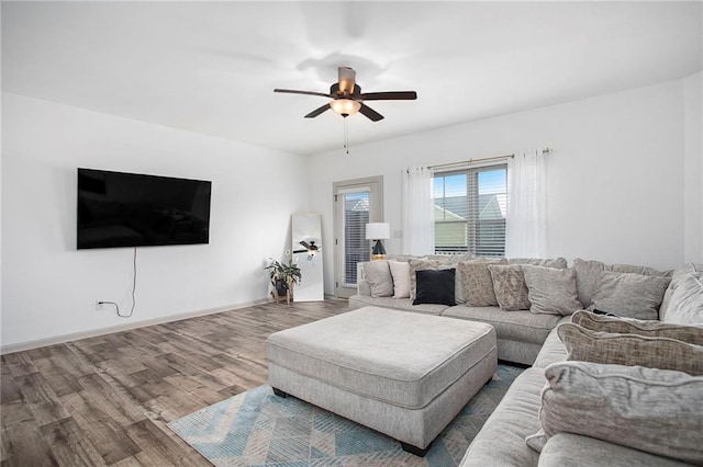 living area featuring ceiling fan, wood finished floors, and baseboards