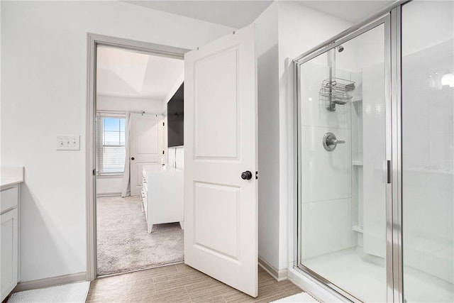 bathroom with a shower stall, vanity, and baseboards