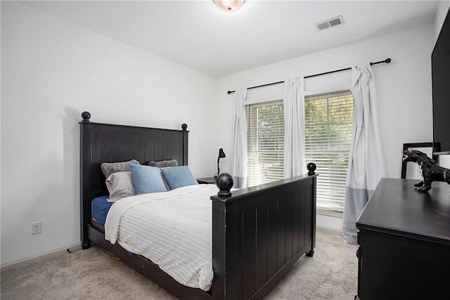 bedroom with light colored carpet, visible vents, and baseboards