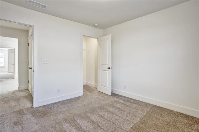 unfurnished bedroom with carpet floors, visible vents, and baseboards