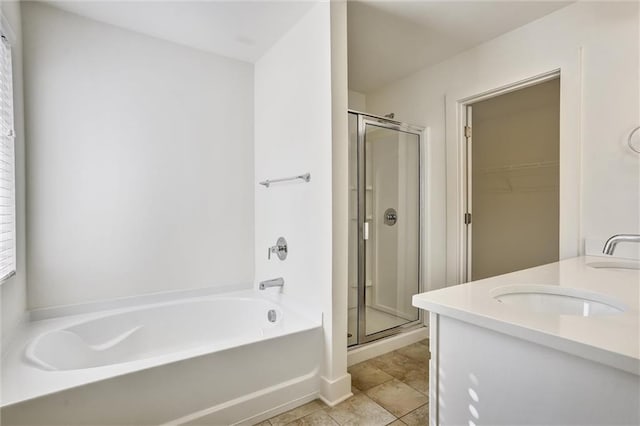 bathroom with a stall shower, tile patterned floors, a sink, and a bath