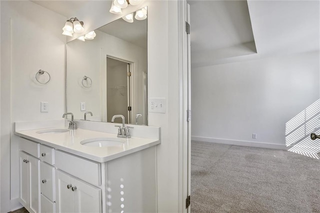 full bathroom featuring a sink, baseboards, and double vanity