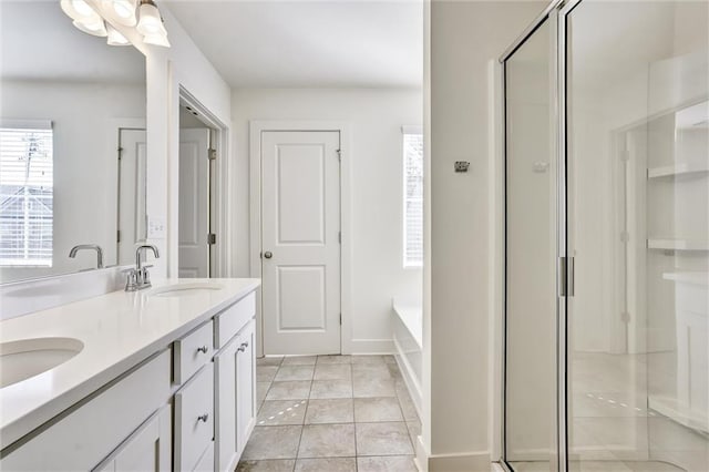 full bath featuring a garden tub, double vanity, a sink, and a shower stall