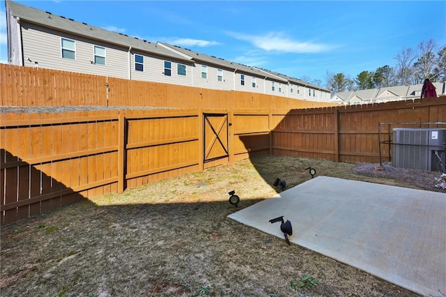 view of yard featuring cooling unit, a patio area, and a fenced backyard