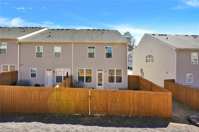 rear view of house with a fenced backyard