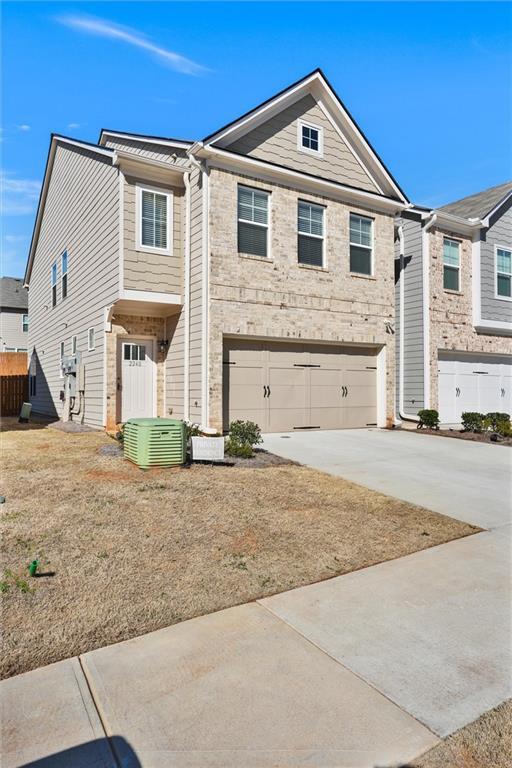 view of front of home featuring a garage, concrete driveway, central AC, and fence