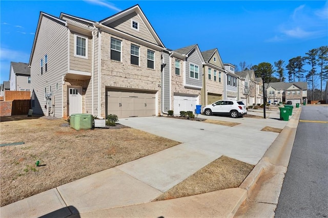 view of front of home featuring a garage, a residential view, concrete driveway, and central AC