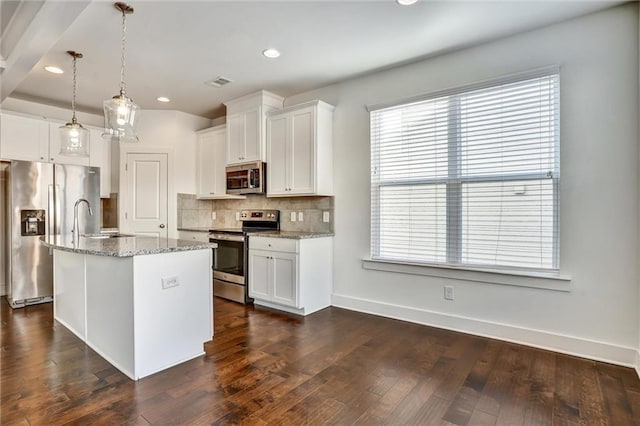 kitchen featuring appliances with stainless steel finishes, white cabinets, dark wood finished floors, and decorative backsplash