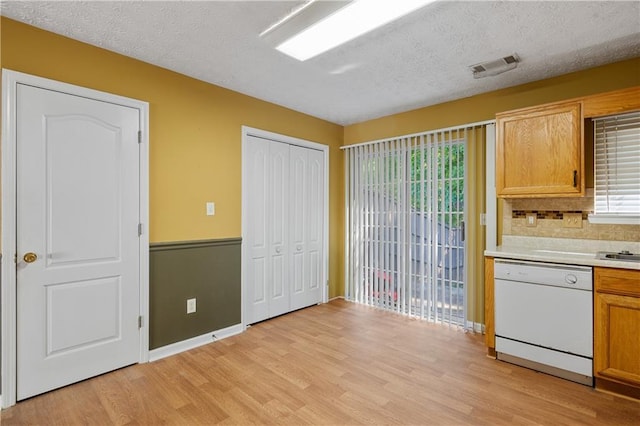 3127 Fields Dr, Lithonia, GA 30038 - kitchen with dishwasher, light wood-type flooring, light countertops, plenty of natural light, and a textured ceiling