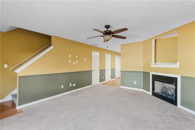 3127 Fields Dr, Lithonia, GA 30038 - unfurnished living room with ceiling fan, a fireplace, a textured ceiling, carpet flooring, and stairway