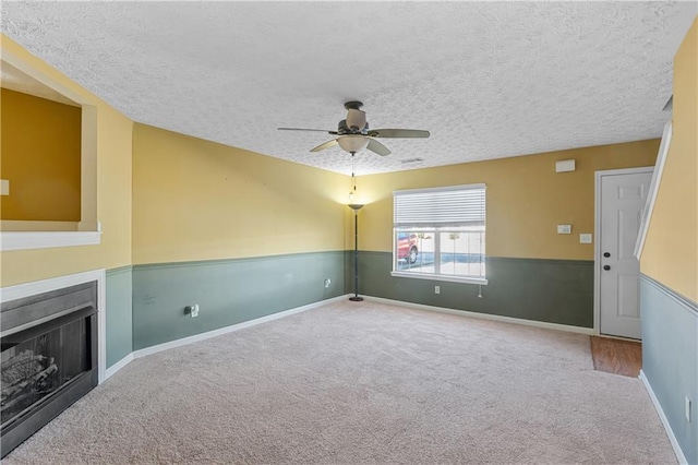 3127 Fields Dr, Lithonia, GA 30038 - unfurnished living room featuring a textured ceiling, a ceiling fan, carpet flooring, a fireplace, and baseboards