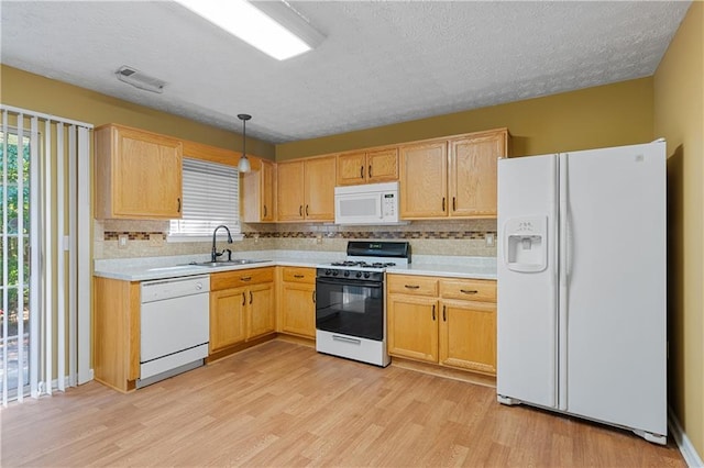 3127 Fields Dr, Lithonia, GA 30038 - kitchen with white appliances, light wood-type flooring, a sink, decorative backsplash, and light countertops