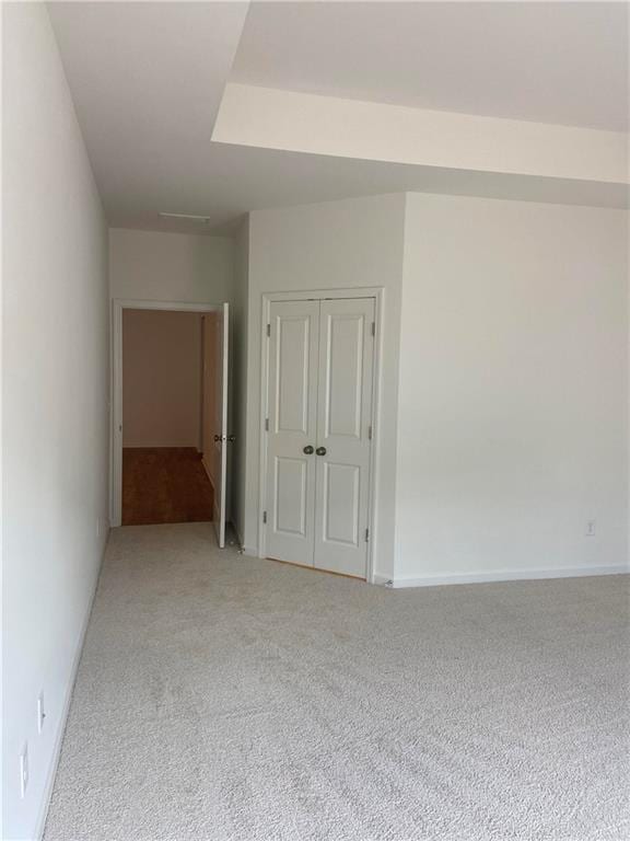 unfurnished room featuring light carpet