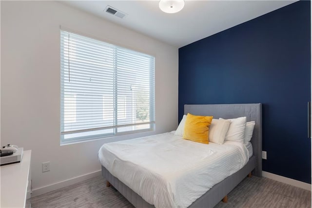 bedroom with baseboards and visible vents