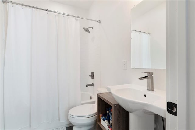 bathroom featuring a sink, shower / bathtub combination with curtain, and toilet