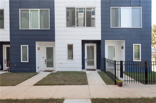 multi unit property with fence and a front yard