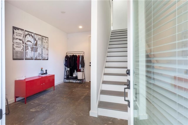 staircase featuring recessed lighting, baseboards, and finished concrete floors